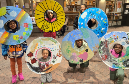 Kids and grown-ups hold up doughnut crafts